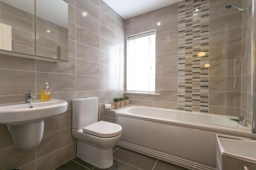 un bagno con un water, una vasca e un lavandino di The Perfect Stay Belfast a Belfast