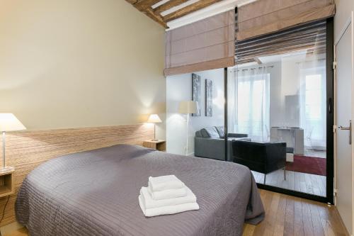 a bedroom with a bed with two white towels at Le Marais Place Sainte Catherine With AC in Paris