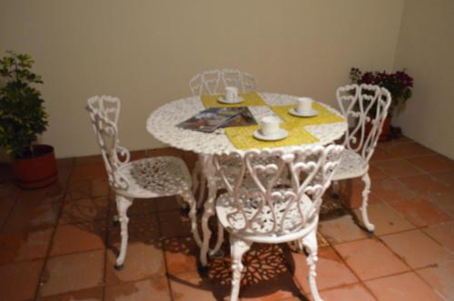 a white table and chairs with a table and drinks on it at Hotel Gran Mariscal Quito in Quito