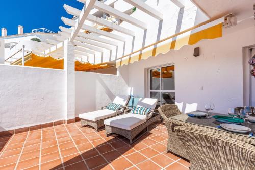 a patio with wicker chairs and a table at El Dorado by Puerto Banus in Marbella