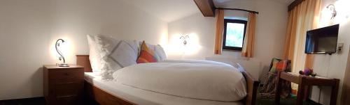 a bedroom with a white bed and a window at Sportpension Christina by PiaundDirk in Fügen