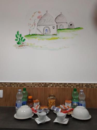 a table with plates and bowls and bottles on it at Suite 30 mq in Palo del Colle