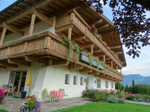 a building with a balcony with flowers on it at Sportpension Christina by PiaundDirk in Fügen