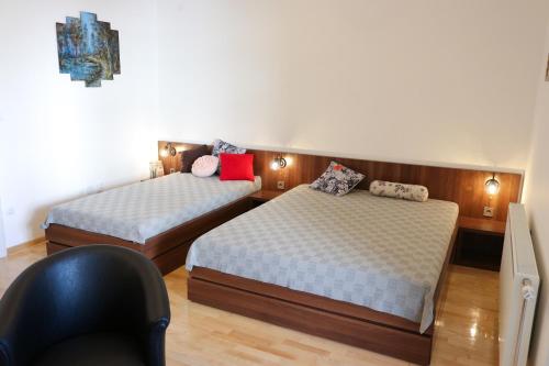 um quarto com 2 camas e uma cadeira em DM apartment em Niš