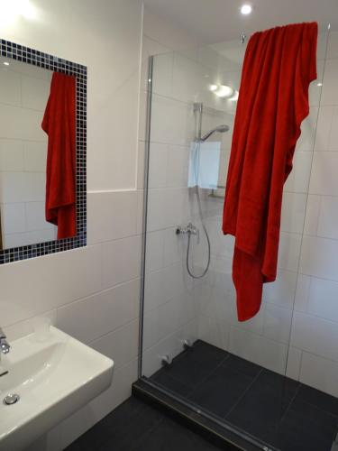 a bathroom with a shower and a red towel at Sportpension Christina by PiaundDirk in Fügen