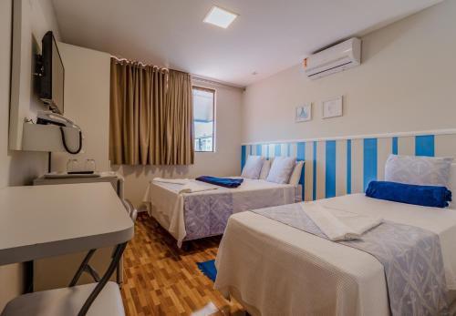 Habitación de hotel con 2 camas y TV en Pousada Tropical Bessa, en João Pessoa