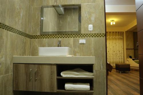 La salle de bains est pourvue d'un lavabo et d'un miroir. dans l'établissement hotel el parral suite, à Ica