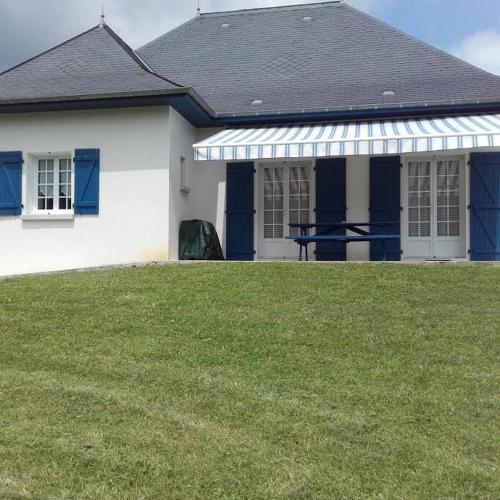 a white house with blue doors and a green yard at Gîte Etchegoyhen in Lacarry-Arhan-Charritte-de-Haut