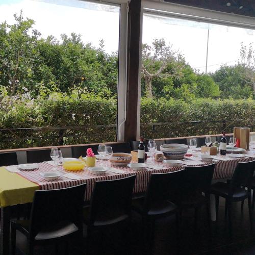 a table with chairs and a table with wine glasses at Villa Rosa in Modica