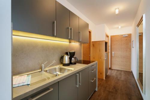 a kitchen with a sink and a counter at Appartement-Hotel Beatenhof in Tirolo