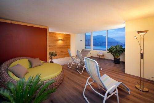 a bedroom with a bed and chairs and a table at Appartement-Hotel Beatenhof in Tirolo