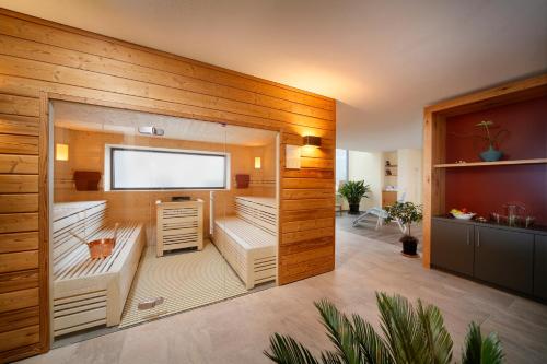 a sauna with wooden walls and a flat screen tv at Appartement-Hotel Beatenhof in Tirolo