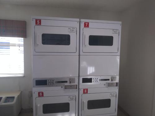four white microwaves stacked on top of each other at Intown Suites Extended Stay Dallas TX - Garland in Garland