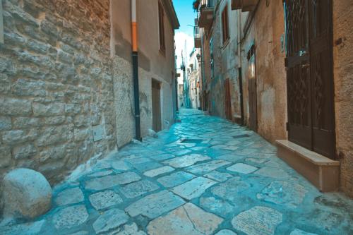 an alley in an old town with blue stones at Il Vicolo - Affittacamere in Ruvo di Puglia