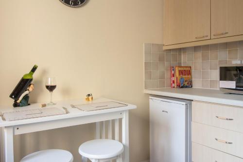 a kitchen with a counter with a wine glass and stools at South Groathill - Lovely 2 bed with Castle View in Edinburgh