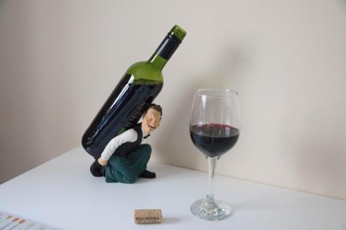 a bottle of wine sitting next to a wine glass at South Groathill - Lovely 2 bed with Castle View in Edinburgh