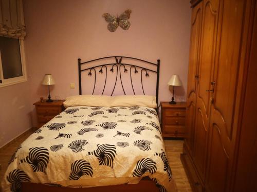 a bedroom with a bed with a butterfly on the wall at Casa Aridani in Arucas