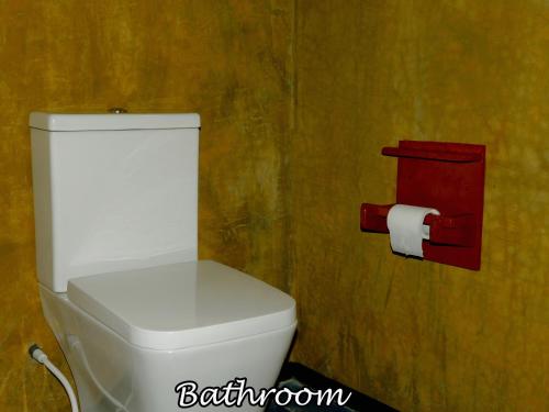 a white toilet in a bathroom with a roll of toilet paper at Yala Avian Eye Safari in Buttala