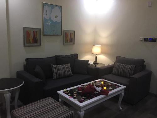 a living room with a couch and a coffee table at Golden Bujari AlUlaya Hotel in Al Khobar