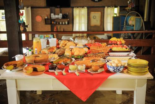 een tafel met een heleboel verschillende soorten voedsel bij Encantos do Vale Pousada e SPA Cultural in Bueno Brandão
