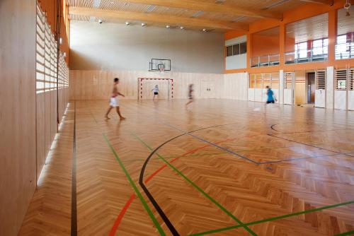 a gymnasium with a basketball court with children playing at JUFA Hotel Leibnitz in Leibnitz