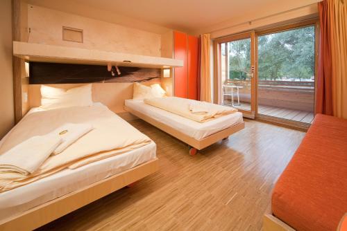 a bedroom with two beds and a large window at JUFA Hotel Leibnitz in Leibnitz