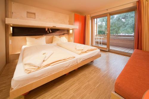 a bedroom with a large bed and a large window at JUFA Hotel Leibnitz in Leibnitz