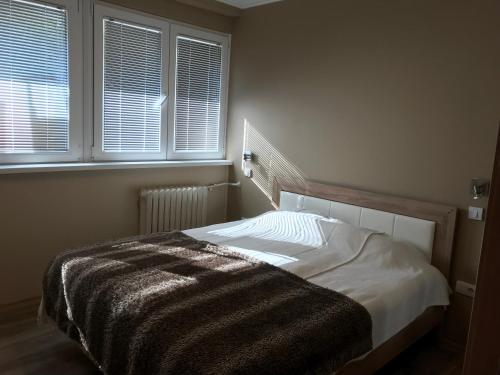 a bedroom with a bed with a blanket on it at Lovely Apartment 2 in Belgrade