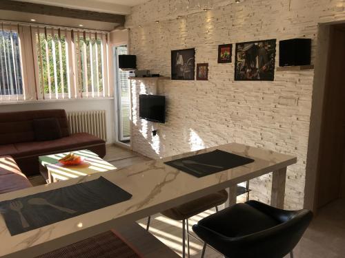 a living room with a table and a brick wall at Lovely Apartment 2 in Belgrade