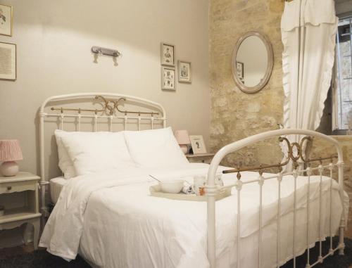 une chambre avec un lit blanc et un miroir dans l'établissement La Forge - Historical Apartment Sarlat, à Sarlat-la-Canéda