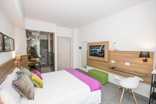 ジャルディーニ・ナクソスにあるIl Muro Vecchio Designのベッドルーム(白いベッド1台、椅子付)