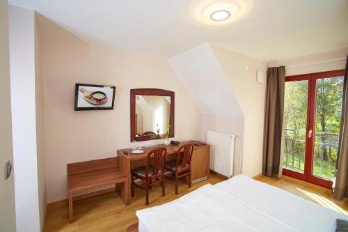 a bedroom with a desk and a mirror and a table at Hotel Delalut in Ravne na Koroškem