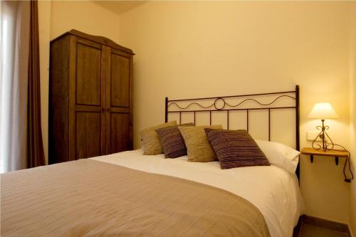 a bedroom with a large white bed and a dresser at Apartaments Rural Montseny in gualba de Dalt
