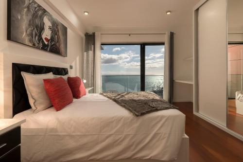 sypialnia z dużym łóżkiem i dużym oknem w obiekcie VILLA PARADISE - Modern and Sophisticated w Funchal