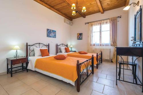 RigliaにあるDaphne Aghios Nikolaos Peloponneseのベッドルーム1室(オレンジのシーツを使用したベッド2台付)