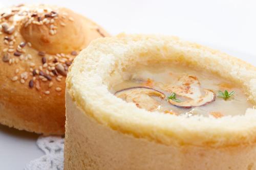 ein Stück Brot mit einer Schüssel Suppe neben einem Bagel in der Unterkunft Hotel Delalut in Ravne na Koroškem