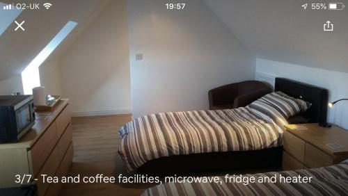 a bedroom with a bed and a desk and a tv at The Loft in Hollingwood