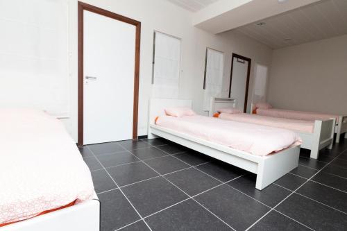 a bedroom with two beds and a tiled floor at jutta in Mechelen