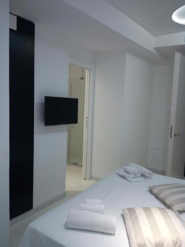 a white bedroom with a bed with towels on it at San Giorgio Modica Hotel in Modica