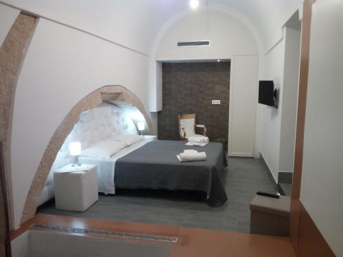 モーディカにあるSan Giorgio Modica Hotelのアーチ道のある部屋で、ベッドルーム1室(ベッド1台付)