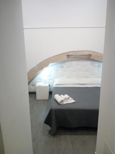 a room with a bed and a table with slippers at San Giorgio Modica Hotel in Modica