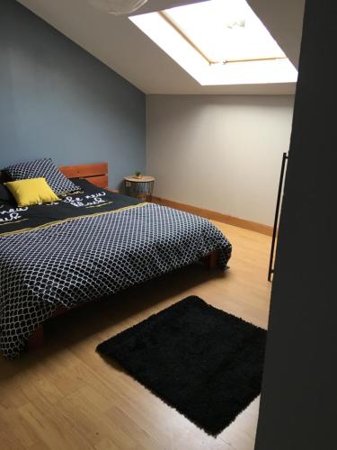 a bedroom with a bed and a skylight at Lamy in Chauny