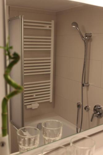 a bathroom mirror with three glasses on a sink at Inside Apartments Speyer in Speyer