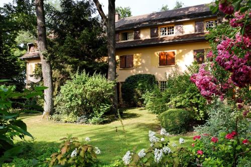 a large yellow house with flowers in the yard at CAZAUDEHORE Hôtel Restaurant Gastronomique Terrasse et Jardins in Saint-Germain-en-Laye