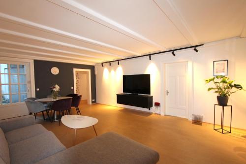 ハンブルクにあるThe Suites Alster Waterfront Family Apartmentsのリビングルーム(ソファ、テーブル付)