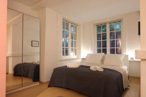 1 dormitorio con 1 cama con 2 toallas en The Suites Alster Waterfront Family Apartments, en Hamburgo