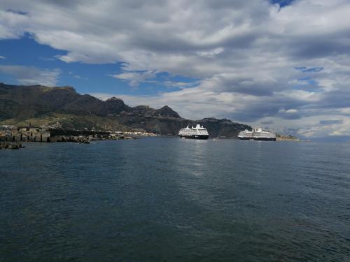 two ships are docked in a large body of water at Namuri Rooms in Giardini Naxos