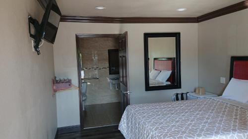 a bedroom with a bed and a shower in it at Santa Ana Travel Inn in Santa Ana