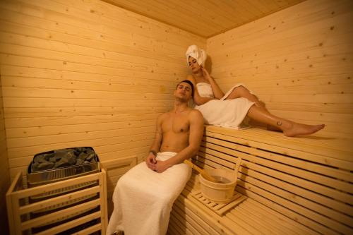 een man en vrouw zittend in een sauna bij Borgo Medievale in Castelmola