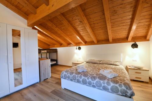 1 dormitorio con cama y techo de madera en Il Gelsomino, en Ornavasso